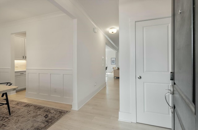 hall with crown molding and light wood-type flooring