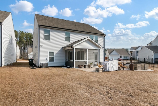 back of house with a jacuzzi, central air condition unit, a sunroom, a lawn, and a patio