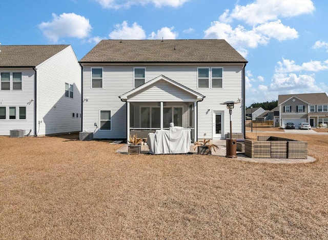 rear view of property with a yard, a patio area, a sunroom, and central AC