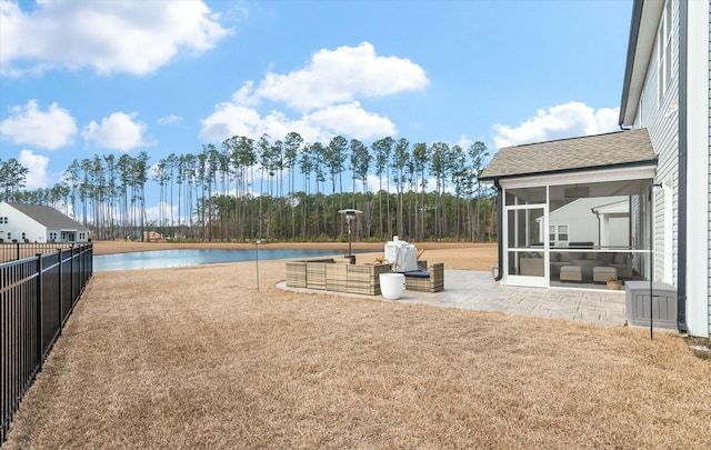 view of yard featuring a water view, a patio, and a sunroom