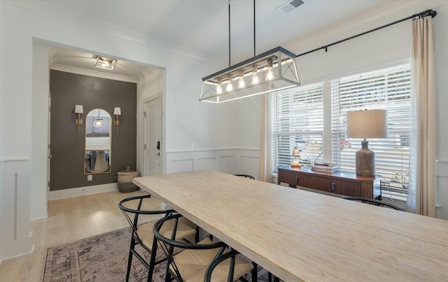 dining space featuring light hardwood / wood-style flooring and ornamental molding