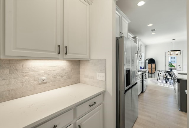 kitchen featuring backsplash, stainless steel appliances, light hardwood / wood-style flooring, and white cabinets