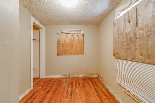 unfurnished room with wood-type flooring and a textured ceiling