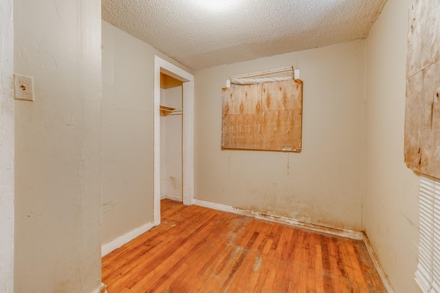 spare room with a textured ceiling and wood-type flooring