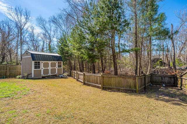 view of yard with a fenced backyard, a storage unit, and an outdoor structure