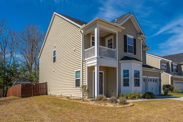 view of front facade with fence, a front yard, a garage, a balcony, and driveway