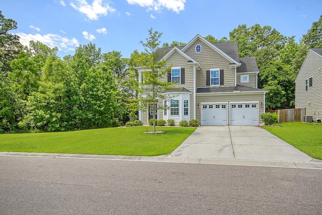 view of front of home featuring a front yard, fence, driveway, central AC, and a garage