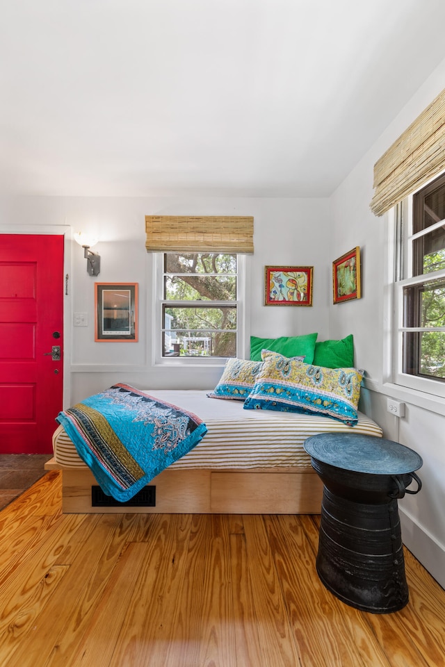 bedroom with multiple windows and hardwood / wood-style floors