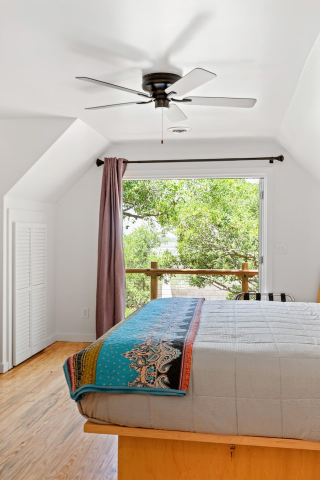 bedroom with ceiling fan, vaulted ceiling, hardwood / wood-style floors, and multiple windows