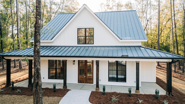 modern farmhouse featuring french doors, metal roof, and a standing seam roof