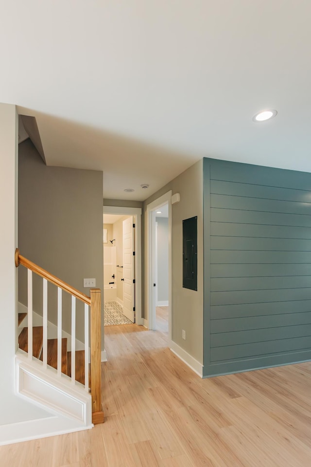 hallway featuring electric panel, recessed lighting, stairway, light wood-style floors, and baseboards