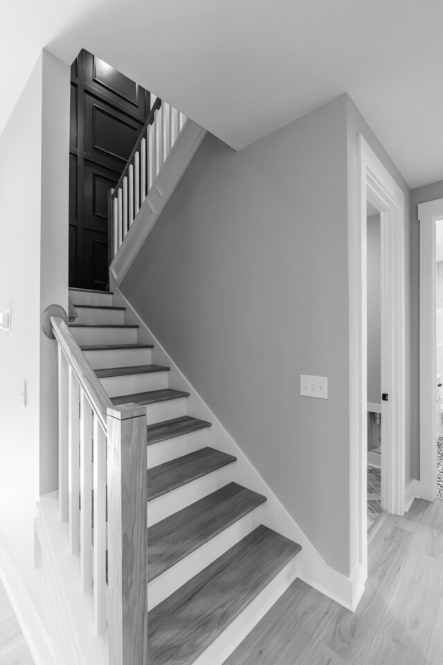 stairway with baseboards and wood finished floors