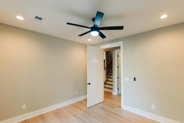 spare room featuring baseboards, light wood-type flooring, and ceiling fan