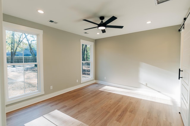 spare room with visible vents, light wood-style floors, and a healthy amount of sunlight