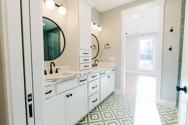 bathroom featuring double vanity, recessed lighting, baseboards, and a sink