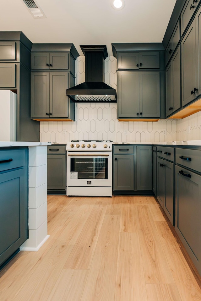 kitchen featuring visible vents, backsplash, light wood-style floors, white appliances, and wall chimney exhaust hood