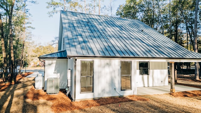 exterior space featuring central AC unit, a patio, metal roof, and a standing seam roof