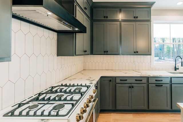 kitchen featuring a sink, light stone countertops, tasteful backsplash, and custom range hood