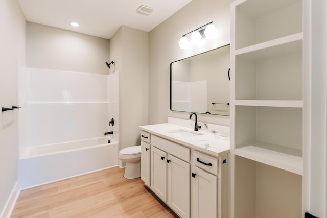 bathroom featuring vanity, washtub / shower combination, wood finished floors, visible vents, and toilet