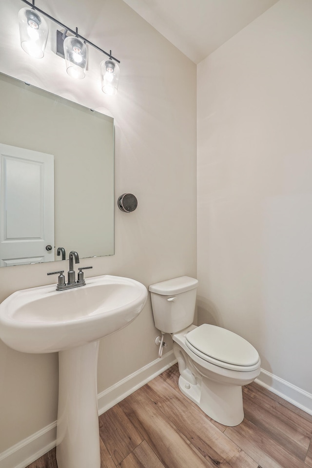 bathroom featuring hardwood / wood-style floors, toilet, and sink