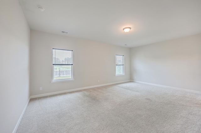 spare room featuring light colored carpet