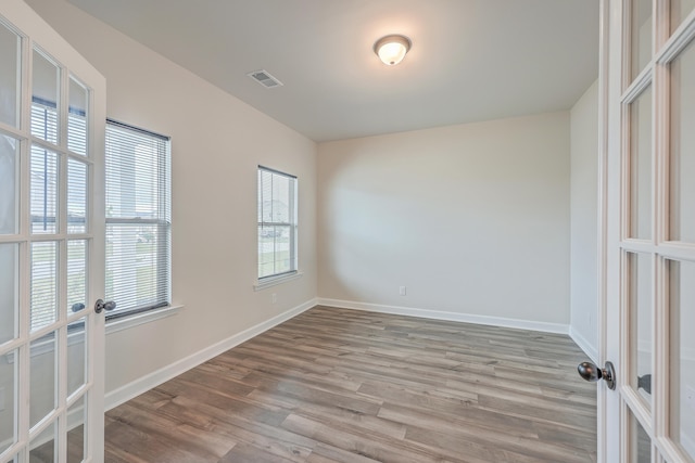 unfurnished room with french doors and light hardwood / wood-style floors