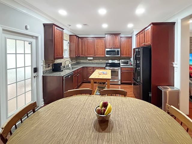 kitchen with sink, appliances with stainless steel finishes, ornamental molding, backsplash, and pendant lighting