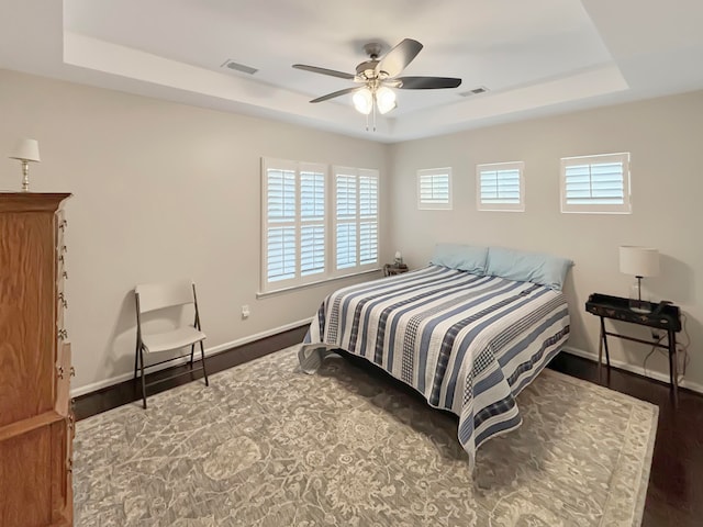 bedroom with multiple windows, ceiling fan, and dark hardwood / wood-style floors