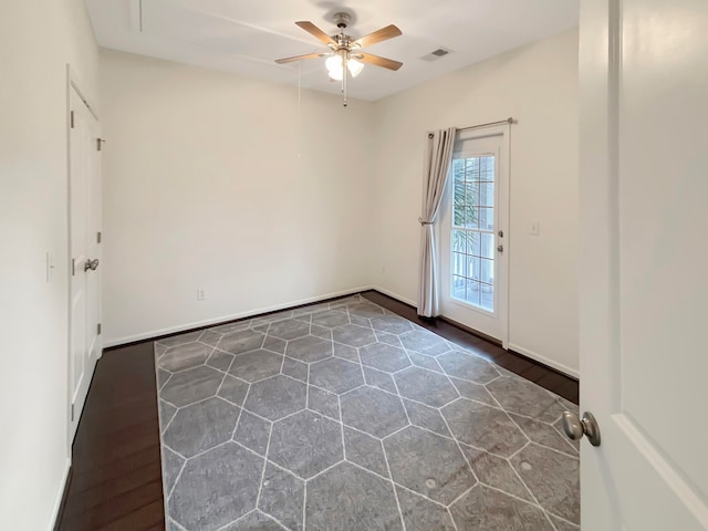 unfurnished room featuring dark hardwood / wood-style floors and ceiling fan