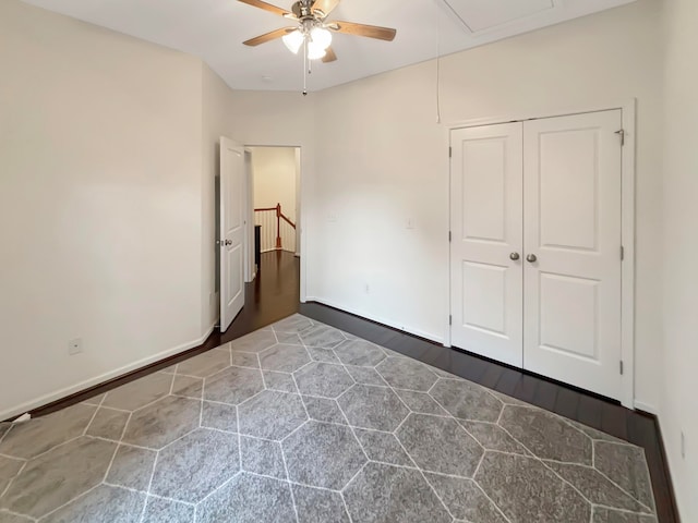 unfurnished bedroom featuring dark wood-type flooring, a closet, and ceiling fan