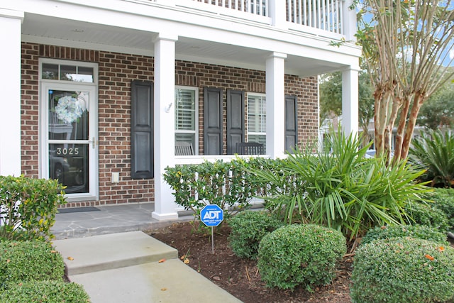 doorway to property with a balcony and covered porch