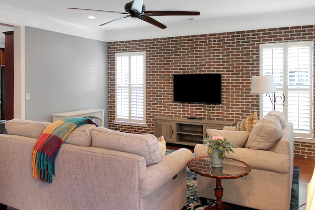 living room featuring brick wall, a healthy amount of sunlight, and ceiling fan