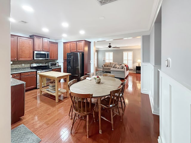 dining area with ornamental molding, light wood-type flooring, and ceiling fan