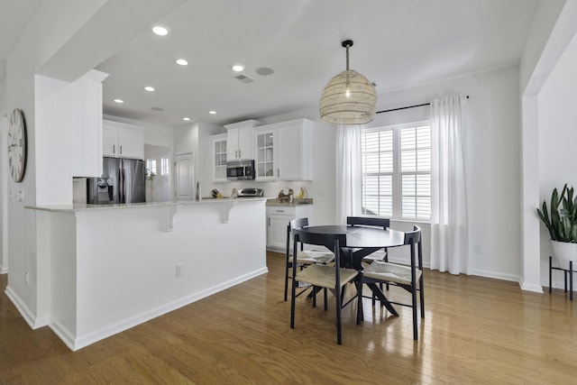 dining space with recessed lighting, visible vents, baseboards, and wood finished floors