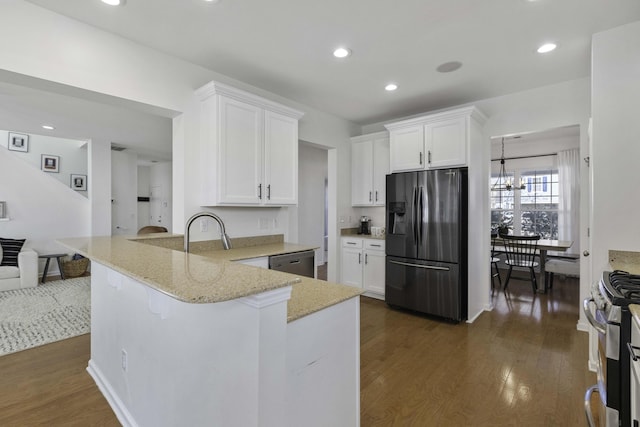 kitchen featuring appliances with stainless steel finishes, dark wood-style flooring, light stone counters, and white cabinets