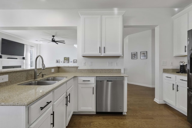 kitchen with white cabinets, dark wood-style floors, light stone countertops, stainless steel dishwasher, and a sink