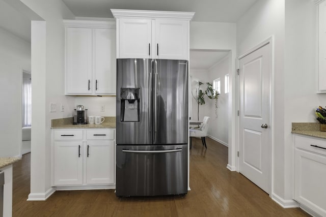 kitchen featuring dark wood-style floors, light stone counters, white cabinets, and stainless steel fridge with ice dispenser