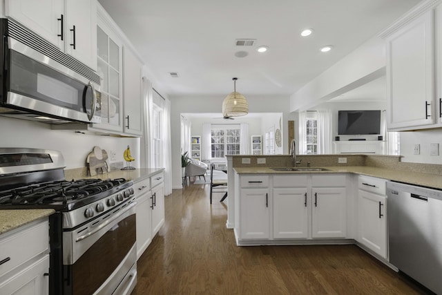 kitchen featuring visible vents, appliances with stainless steel finishes, dark wood-type flooring, white cabinetry, and a sink