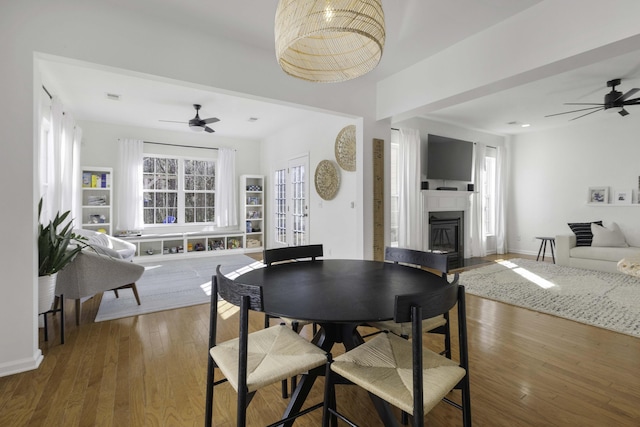 dining space featuring ceiling fan, baseboards, and hardwood / wood-style flooring