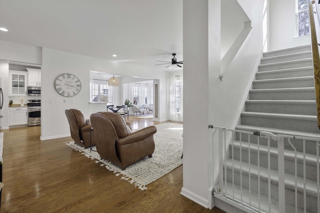 living area with recessed lighting, dark wood finished floors, stairway, and ceiling fan