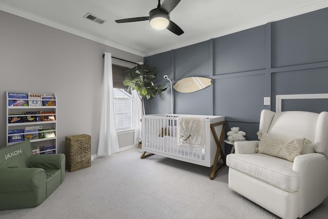 bedroom with visible vents, ornamental molding, a decorative wall, and carpet flooring