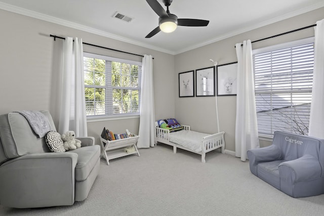 carpeted bedroom featuring ceiling fan, visible vents, and crown molding