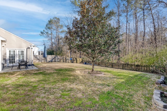 view of yard featuring french doors, a patio area, and a fenced backyard