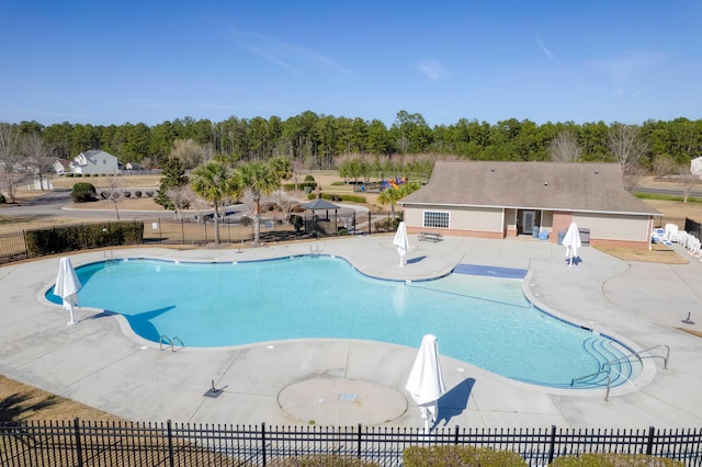 pool with a patio area and fence