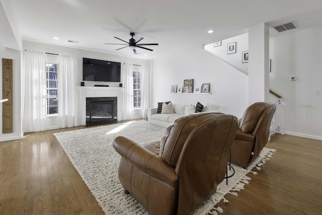 living room with a fireplace with flush hearth, wood finished floors, visible vents, and recessed lighting