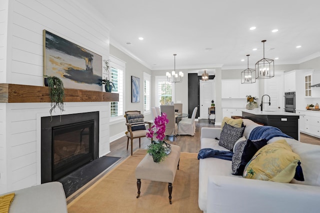 779 Forrest Dr, Charleston, SC 29492 - living room with ornamental molding, light wood-style floors, a chandelier, recessed lighting, and a glass covered fireplace
