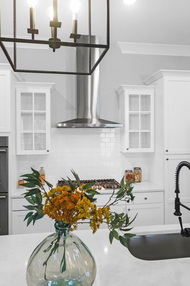 779 Forrest Dr, Charleston, SC 29492 - kitchen with wall chimney exhaust hood, glass insert cabinets, white cabinetry, backsplash, and a sink