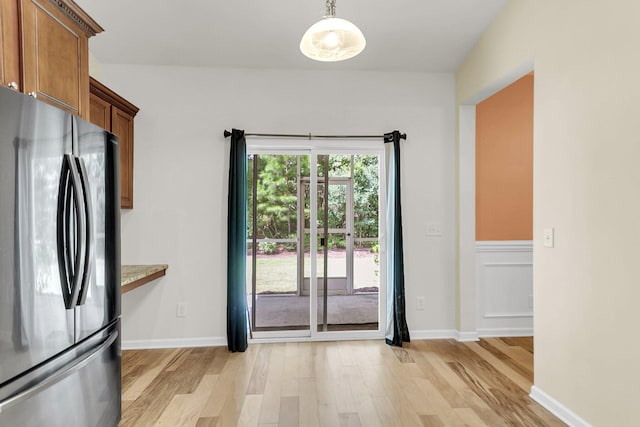 doorway to outside with baseboards and light wood finished floors