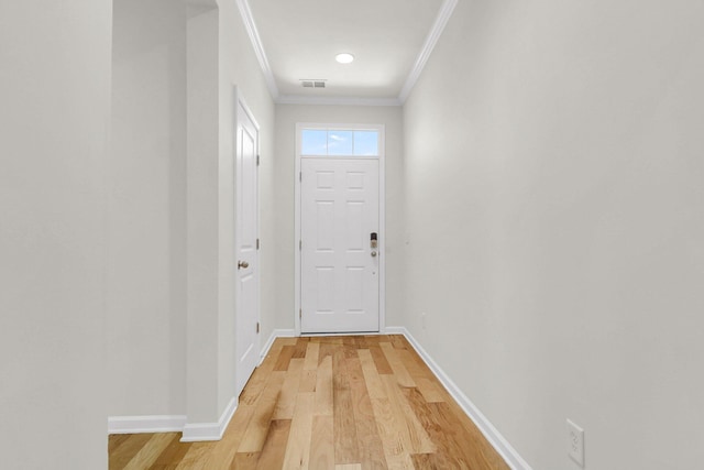 entryway with ornamental molding, baseboards, visible vents, and light wood finished floors