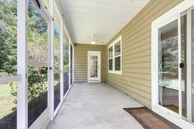 unfurnished sunroom featuring a ceiling fan